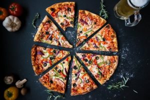 pizza pokrojona na kawałki na czarnym stole